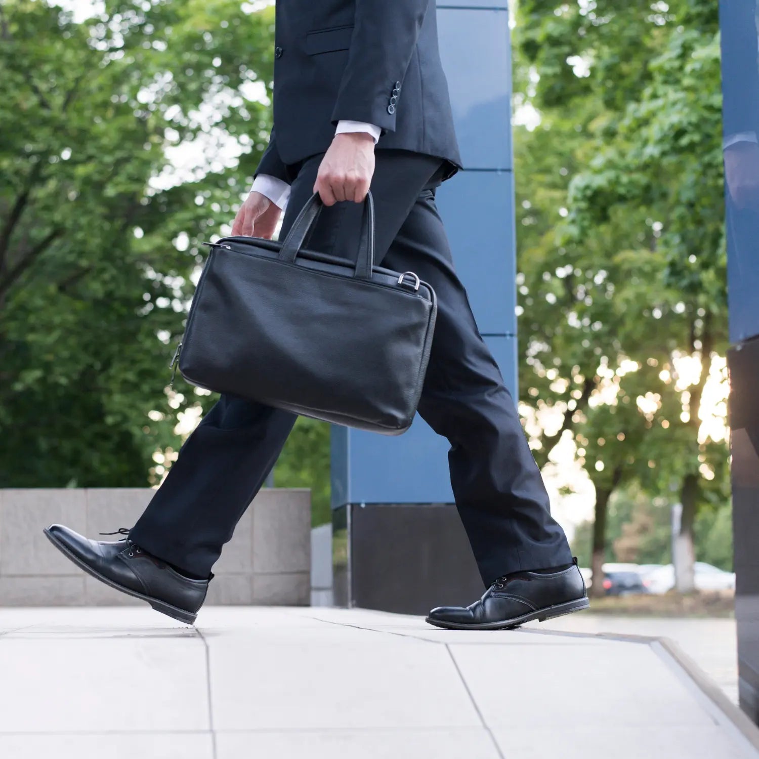 Zakenman met elegante zwarte laptoptas, perfect voor professionele omgevingen en zakelijke afspraken.