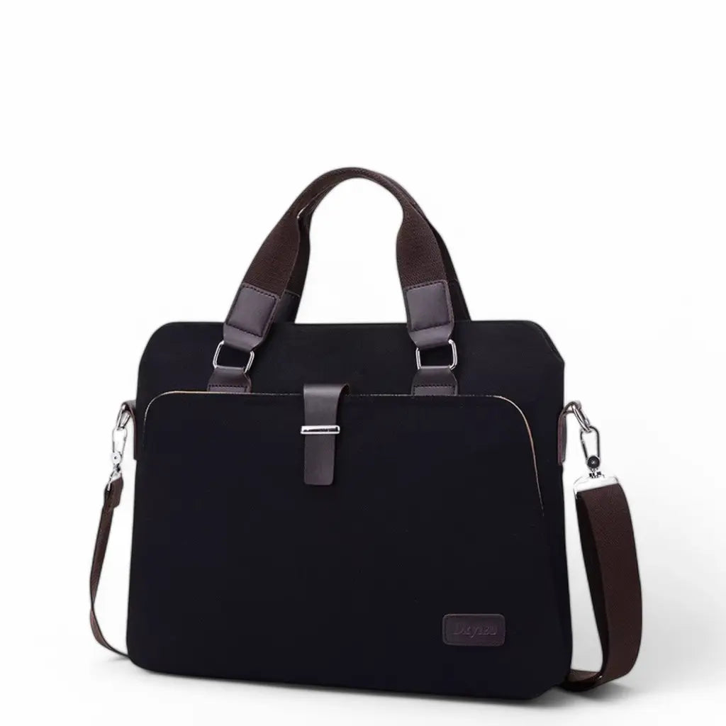 Canvas laptoptas heren in zwarte uitvoering met bruine leren accenten en handgrepen, voorzien van schouderband en voorvakje.