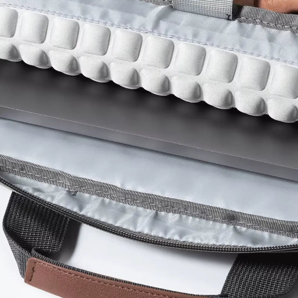 Binnenaanzicht van de design laptoptas heren lichtgrijs met beschermende voering en compartimenten. De close-up toont de gewatteerde bescherming voor elektronische apparaten en het ruime opbergsysteem binnenin de COPTON tas.