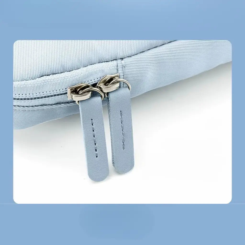 Close-up van de hoogwaardige ritssluiting van de lichtblauwe laptoptas, met stevige metalen treklipjes en verstevigde stiksels
