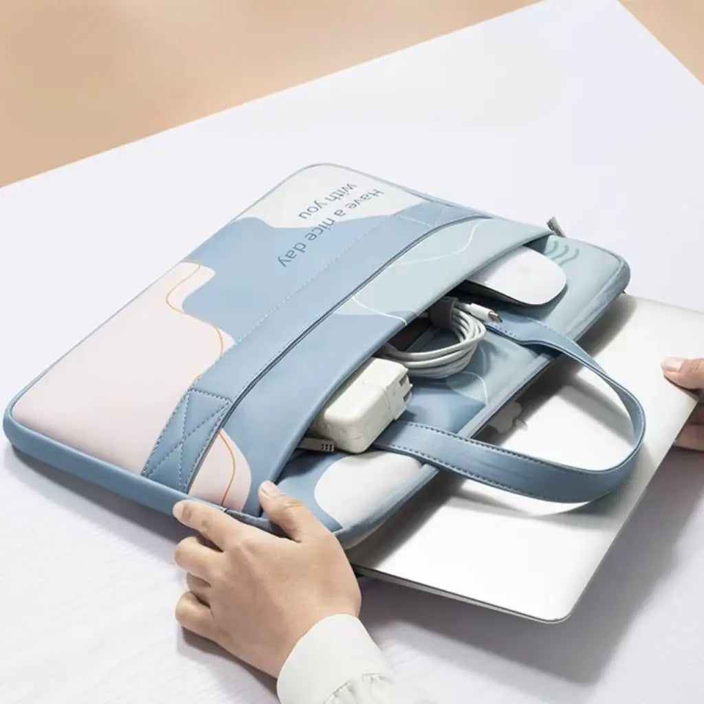 Binnenkant van de gekleurde laptoptas met opbergruimte voor laptop, oplader en accessoires. Een hand opent de blauwe tas met abstract design om de functionele compartimenten te tonen, perfect voor dagelijks gebruik en reizen.