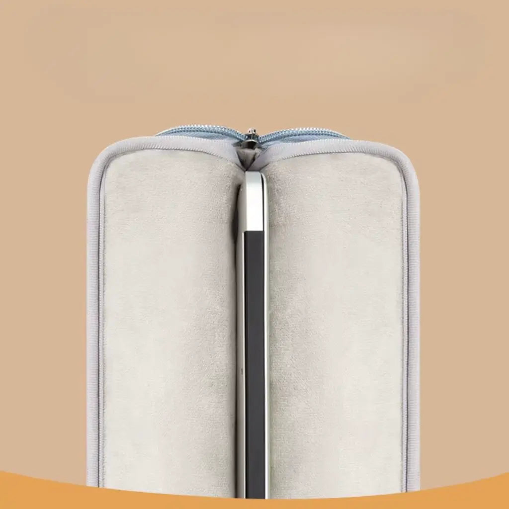 Close-up van de beschermende vulling in de gekleurde laptoptas, getoond met ritssluiting en zachte binnenbekleding. De beige voering biedt extra bescherming voor elektronische apparaten, terwijl de blauwe buitenkant een stijlvol abstract patroon heeft.