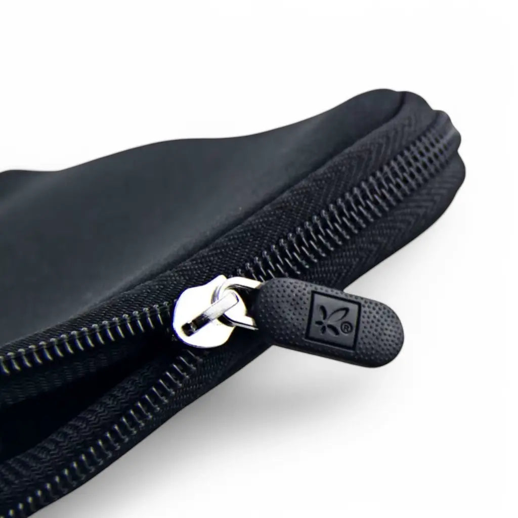 Close-up van de kwaliteitsritssluiting van een flower laptop sleeve met duurzame trekker en merklogo voor optimale laptopbescherming.