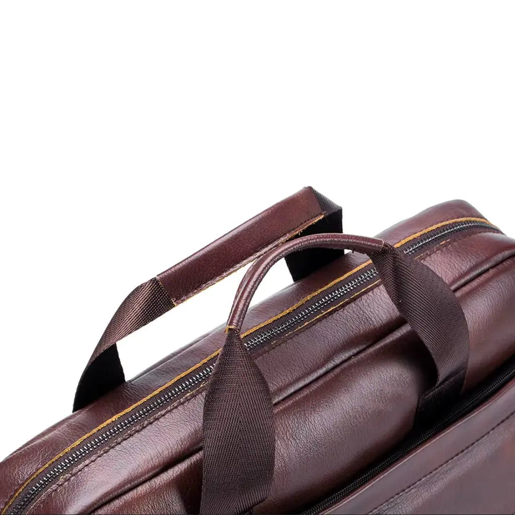 Leren laptoptas heren 14 inch met focus op de gewatteerde handgrepen en ritssluiting met goudkleurige details. Ergonomisch ontwerp voor comfortabel dragen van deze stijlvolle en functionele 14 inch laptoptas.