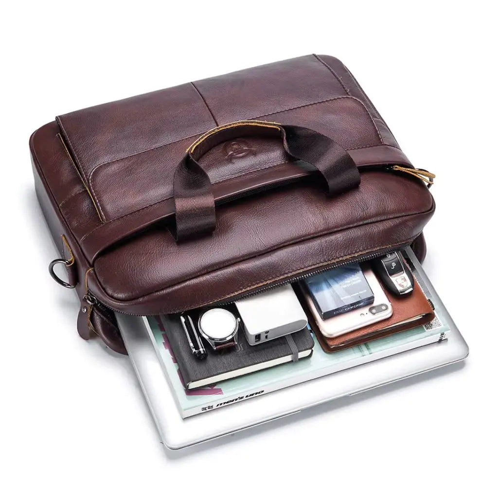 Leren laptoptas heren 14 inch gevuld met laptop, notitieblok, smartphone, horloge en andere kantoorbenodigdheden. Praktische tas met voldoende ruimte voor alle essentiële zakelijke apparatuur en accessoires.
