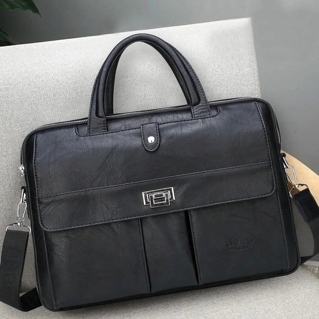 Elegante leren laptoptas 13.3 inch zwart van Jeep met metalen sluiting, dubbele voorvakken, handgrepen bovenaan en afneembare schouderriem, getoond op een lichte bank.