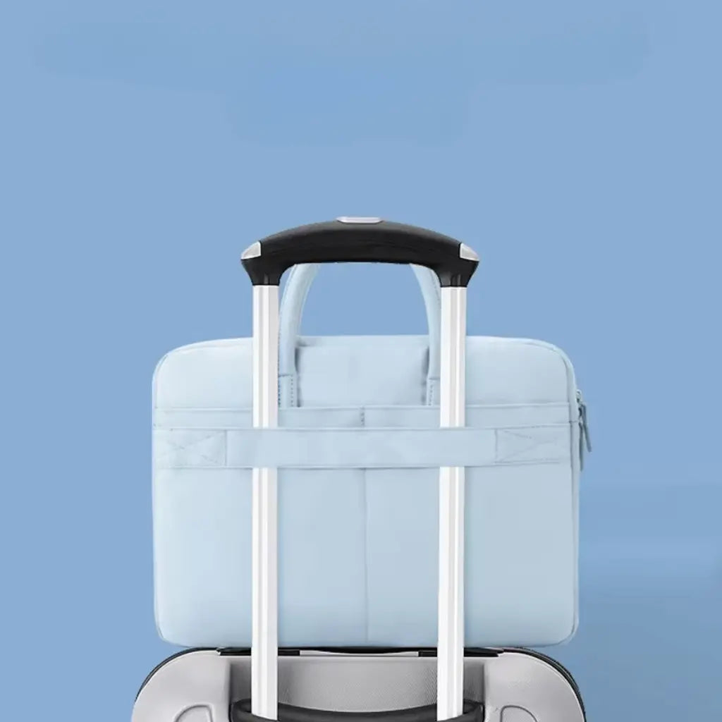 Lichtblauwe laptoptas geplaatst over trolley handgreep, ideaal voor reizen, laat zien hoe de tas veilig op koffer bevestigd kan worden