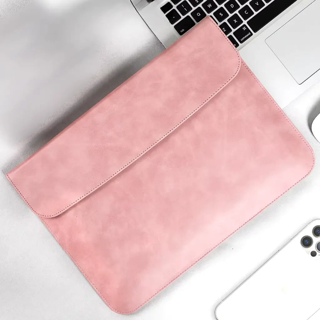 Laptop sleeve roze op een witte ondergrond naast een MacBook keyboard en iPhone, perfect voor dagelijks gebruik.