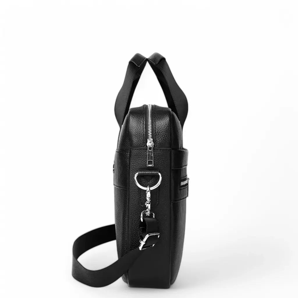Zijaanzicht van de mooie laptoptas heren 15.6 inch zwart met bevestigingspunt voor de schouderband. De tas toont het slanke profiel met handgrepen aan de bovenkant en hoogwaardige afwerking van het premium leer.