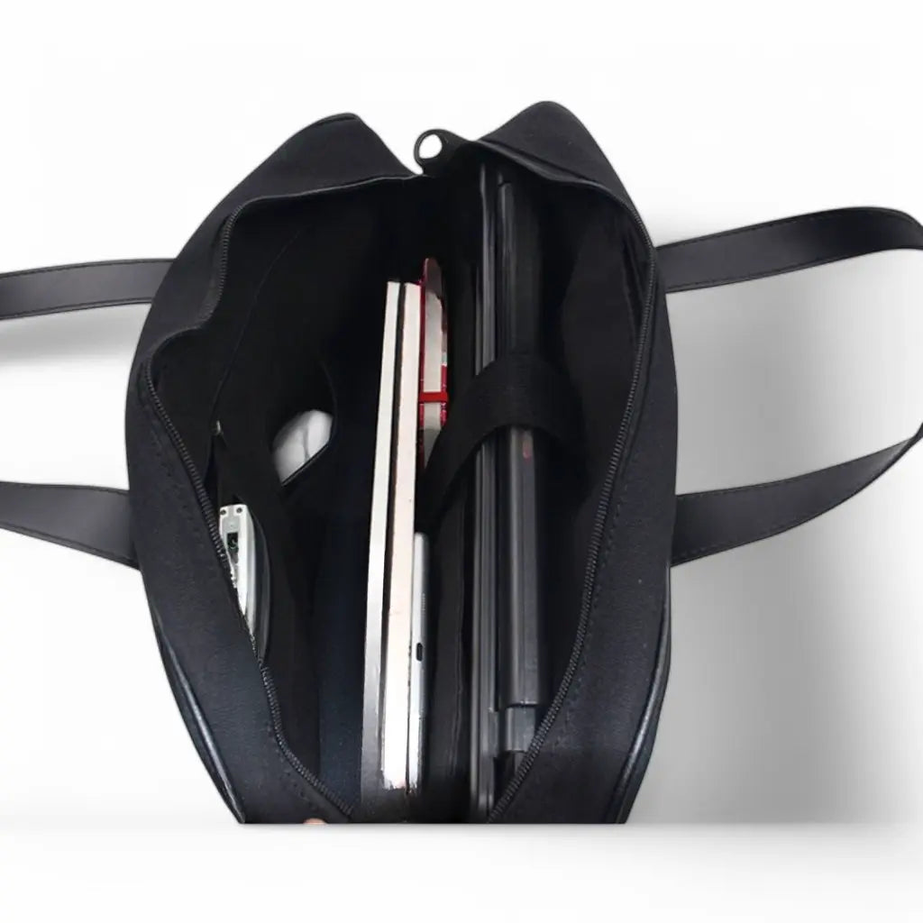 Binnenkant van een flower laptop sleeve met ruime opbergvakken voor laptop, notitieboeken en accessoires, voorzien van stevige handgrepen.