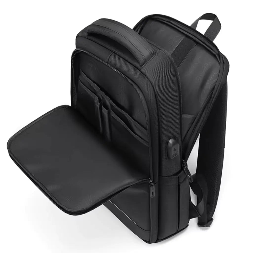 Geopende zwarte waterdichte laptop rugzak 16 inch met meerdere vakken en een georganiseerd interieur.