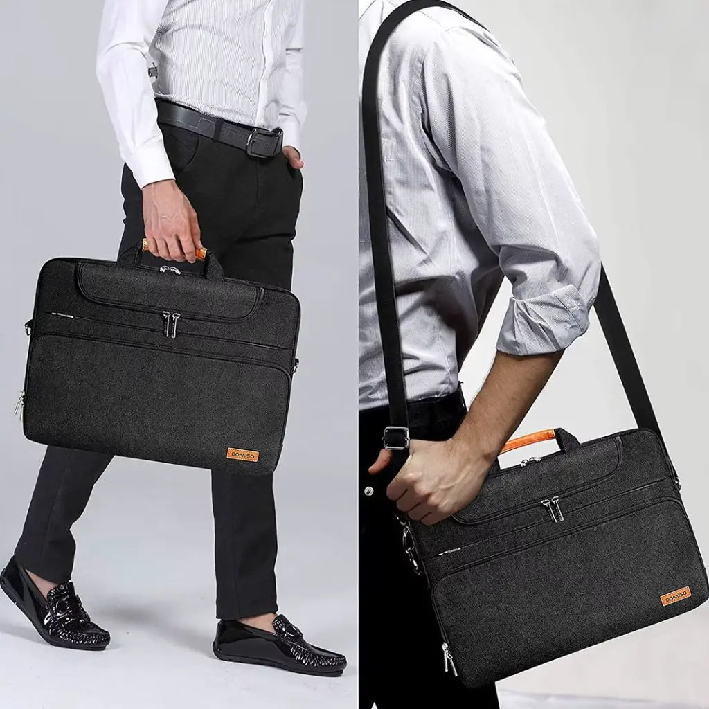 Brede laptoptas heren 17 inch zwart gedragen door een man in zakelijke kleding, waarbij de tas zowel met de hand als over de schouder kan worden gedragen voor veelzijdig gebruik.