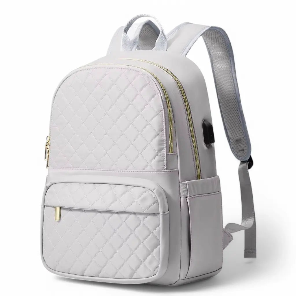 Witte dames laptoprugzak van 15.6 inch met gewatteerd patroon, gouden ritsen en zijvakken voor extra opbergruimte.