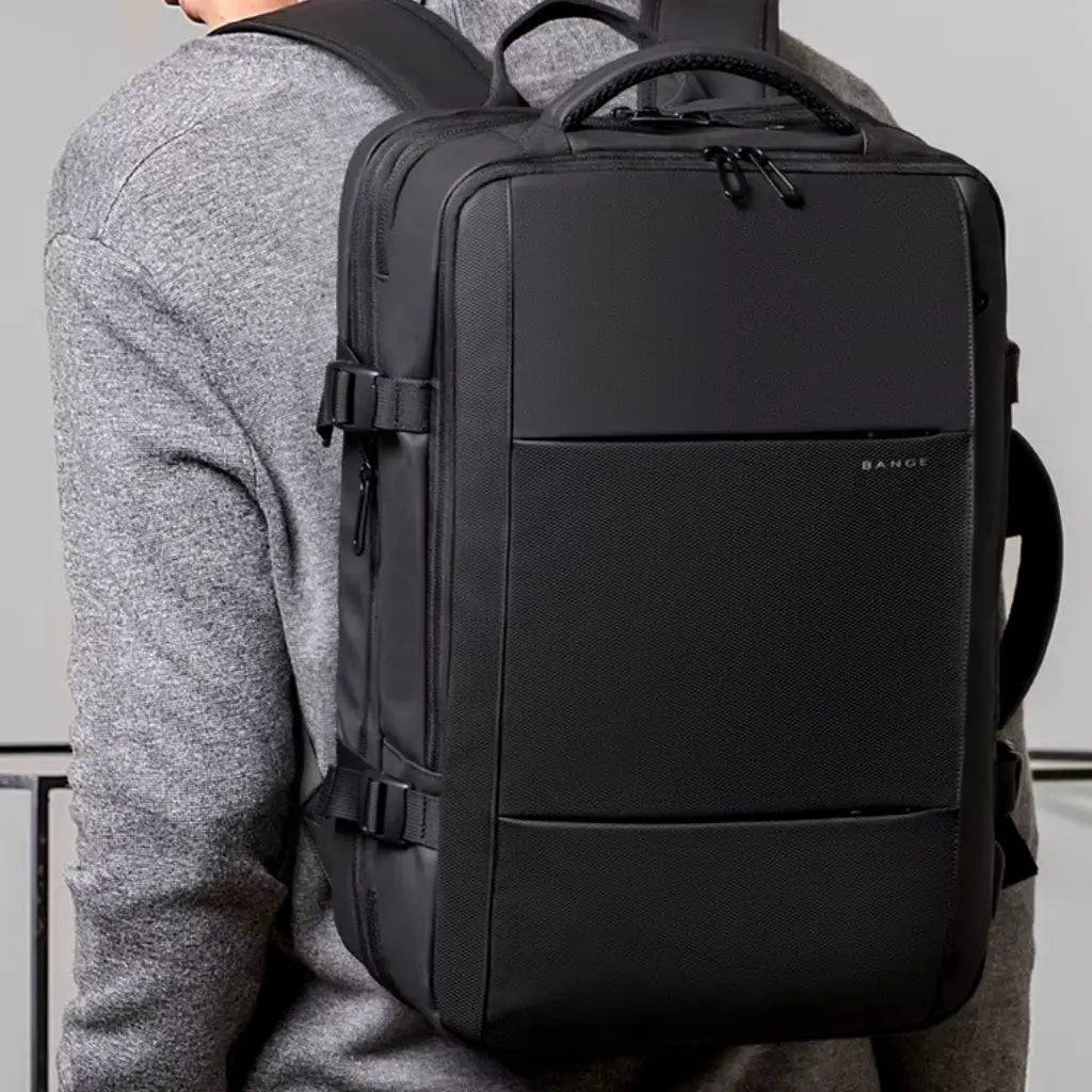 Man in een grijze trui draagt een design laptop rugzak 16 inch, perfect voor dagelijks gebruik en professioneel reizen.