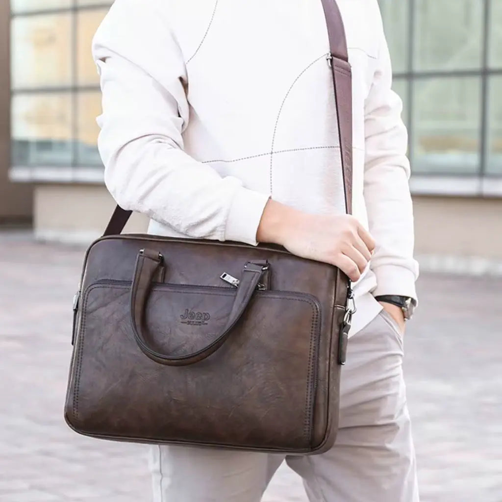 Exclusieve laptoptas heren 14 inch donkerbruin gedragen door een man in witte kleding, toont de praktische schouderband en compacte vormgeving voor de moderne Nederlander.