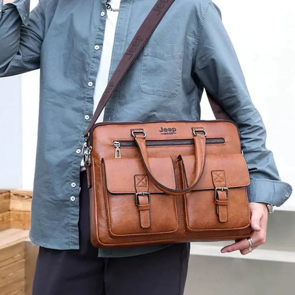 Man in blauwe overhemd draagt een leren laptoptas heren 13 inch bruin met schouderriem, getoond in dagelijks gebruik met duidelijk zichtbaar Jeep logo aan de voorkant.
