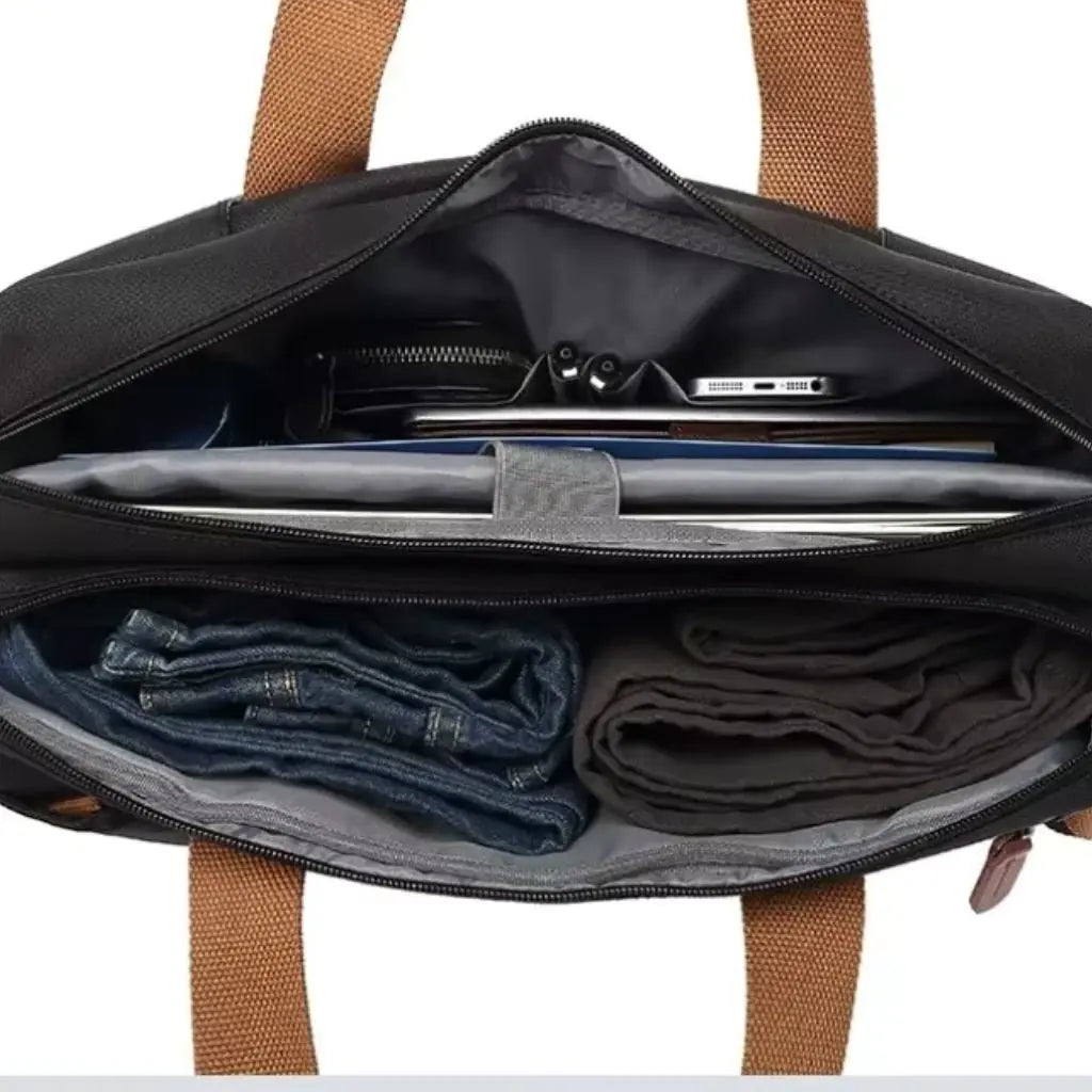 Binnenaanzicht van een grote laptoptas heren met georganiseerde vakken voor laptop, kleding en accessoires, met bruine handvatten aan de bovenkant.