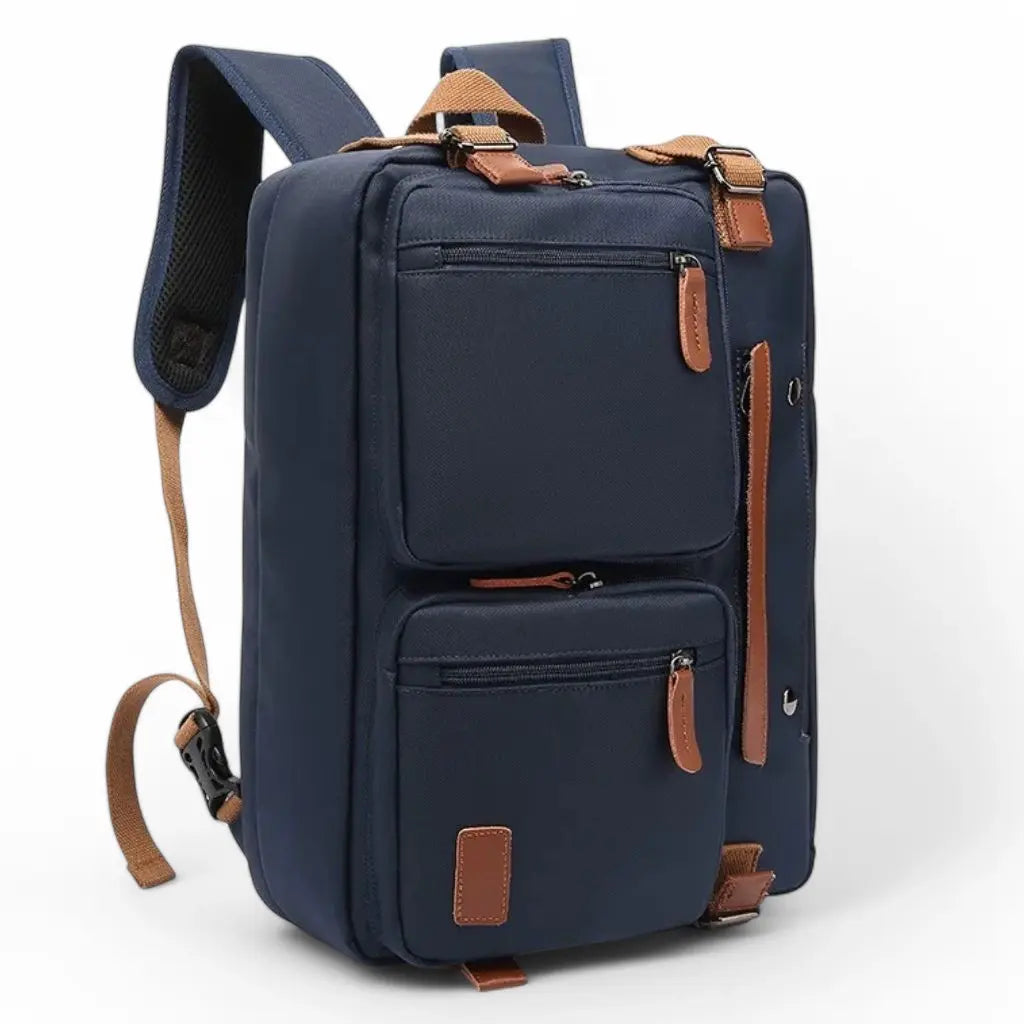 Grote laptoptas heren blauw in rugzak-uitvoering met meerdere compartimenten en bruine lederen accenten. De veelzijdige marineblauw tas heeft verstelbare schouderriemen, verschillende opbergvakken met ritssluiting en decoratieve metalen details.