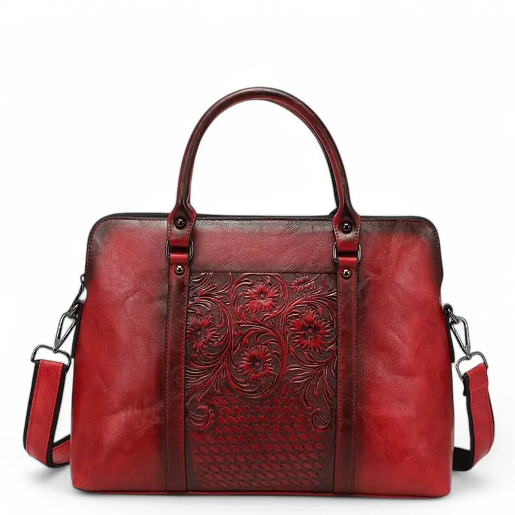 Rode leren vintage laptoptas voor dames van 14 inch met prachtige handgegraveerde bloemmotieven op de voorkant. Deze unieke tas heeft een verweerd vintage-effect, twee stevige handvatten en een afneembare schouderriem. De laptoptas combineert klassieke ambachtelijke details met praktische functionaliteit, ideaal voor dagelijks gebruik. Leren vintage laptoptas dames 14 inch rood.