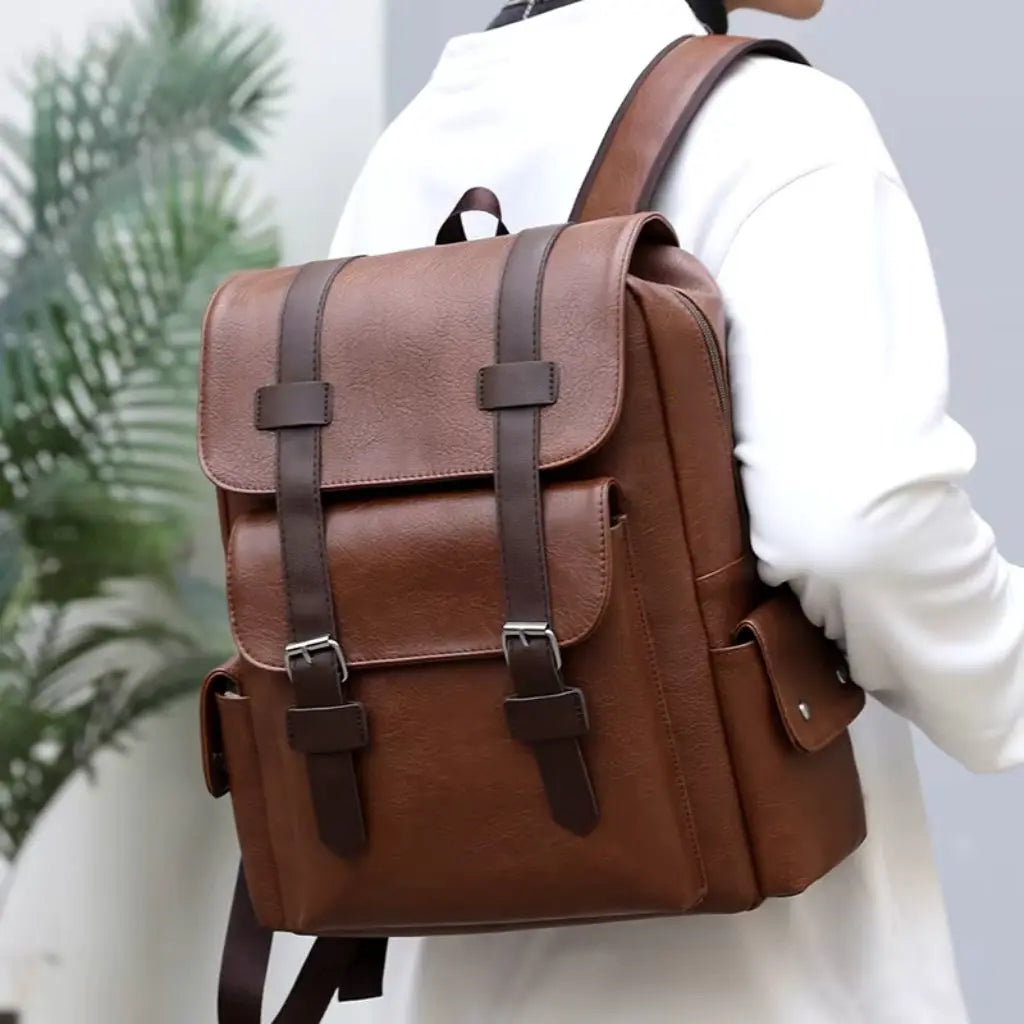 Zijaanzicht van de Heren laptop rugzak 13 inch bruin, gedragen door een man in een witte trui. De rugzak heeft een stijlvol en duurzaam ontwerp.
