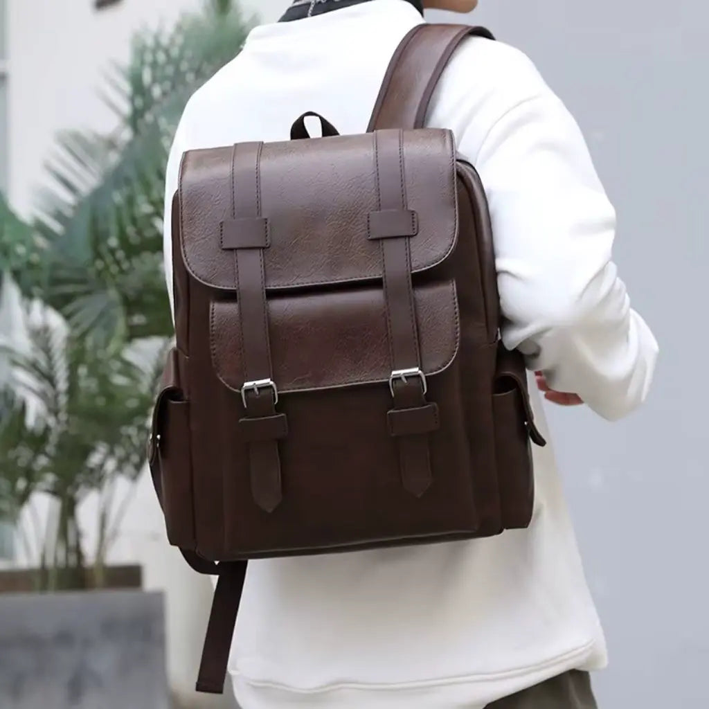 Een man draagt de Heren laptop rugzak 13 inch Donkerbruin op de rug. De rugzak combineert een vintage uitstraling met moderne functionaliteit.