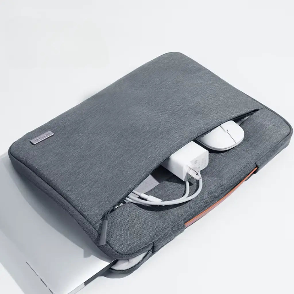 Opengeslagen laptop hoes met handvat toont zachte witte voering voor extra schokbescherming en een zilverkleurige laptop.