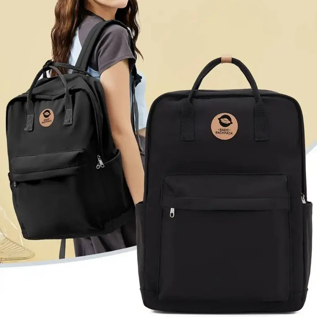 Meisje draagt een zwarte laptop rugzak 14 inch op haar rug. De tas heeft een modern en trendy design met stevige schouderbanden en een ruim hoofdvak.