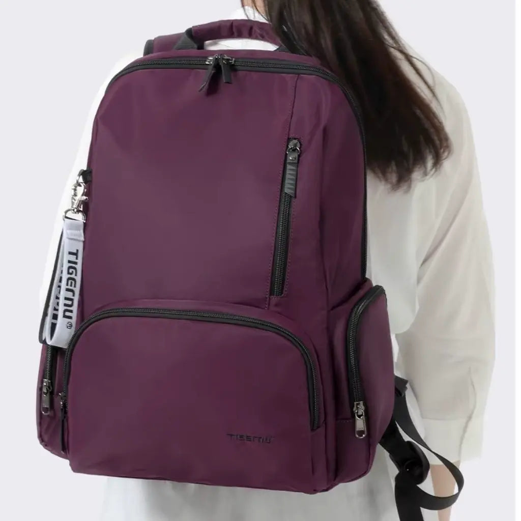 Vrouw draagt een laptop rugzak 14 inch paars, comfortabel en stijlvol voor dagelijks gebruik.