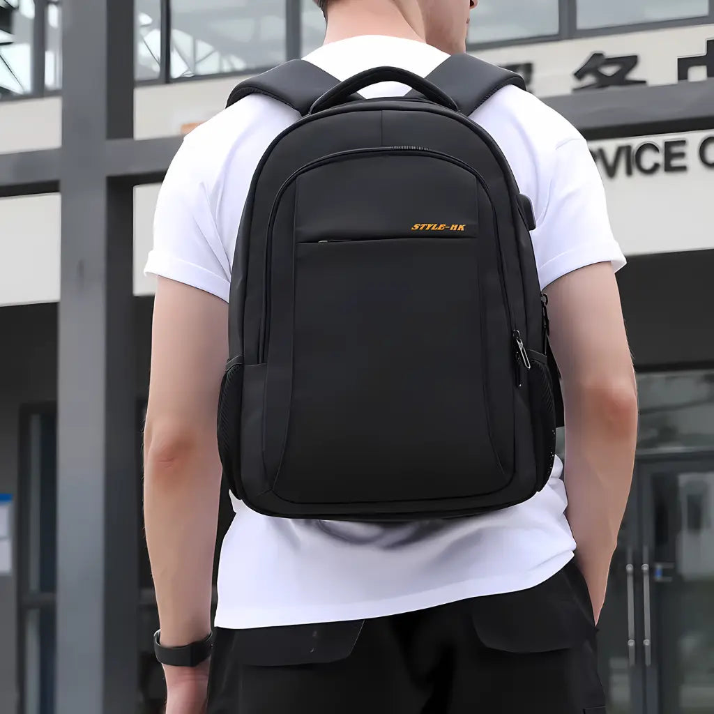 Jongeman draagt een laptop rugzak 15.6 inch middelbare school in een stedelijke omgeving, ideaal voor dagelijks gebruik.