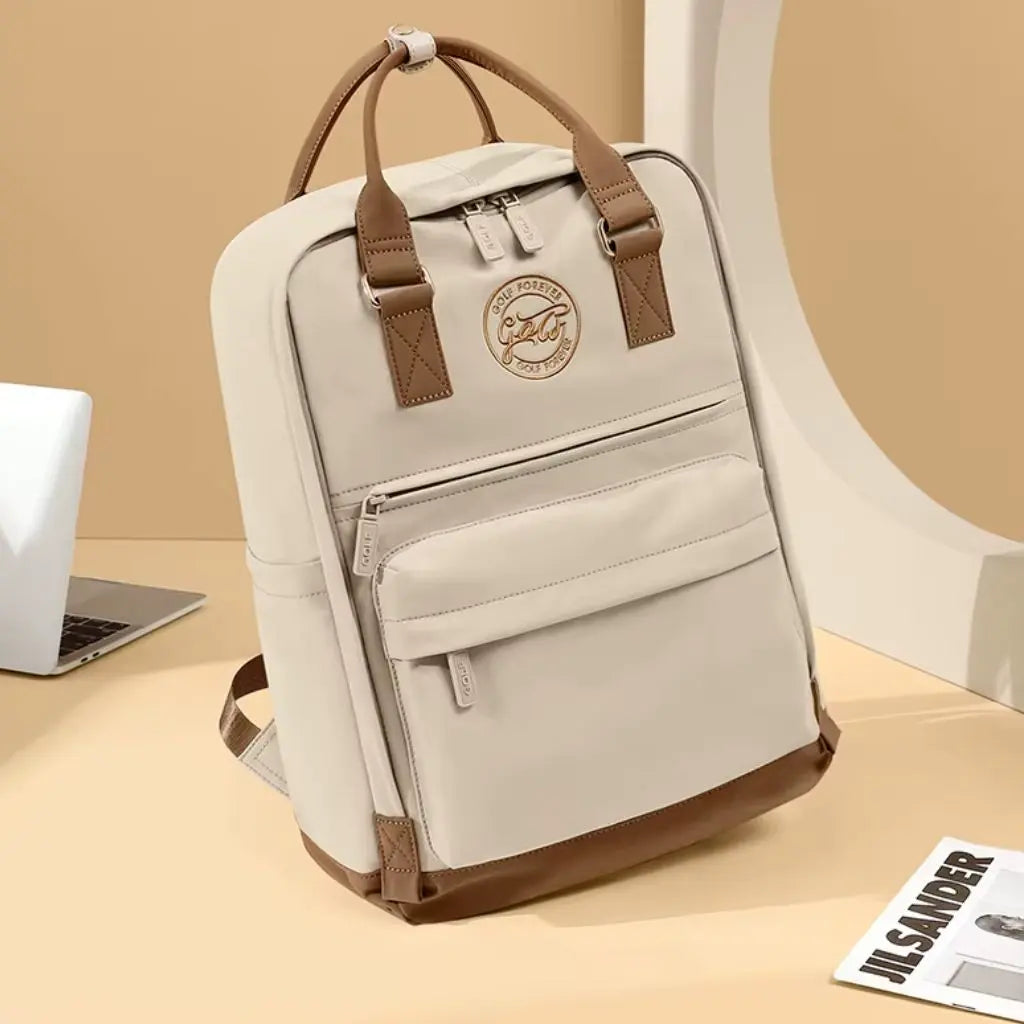 Crèmekleurige laptop rugzak dames 16 inch op een beige kantoor naast een laptop. De elegante rugzak heeft een tijdloos Scandinavisch design met functionele vakken en is perfect voor moderne professionals die waarde hechten aan stijl en duurzaamheid.