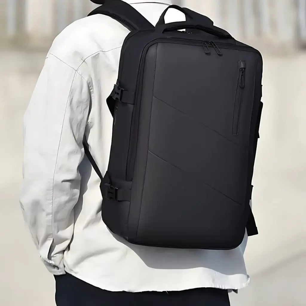 Man draagt een zwarte laptoprugzak voor heren van 15 inch, met een strak en professioneel design, ideaal voor werk en reizen.