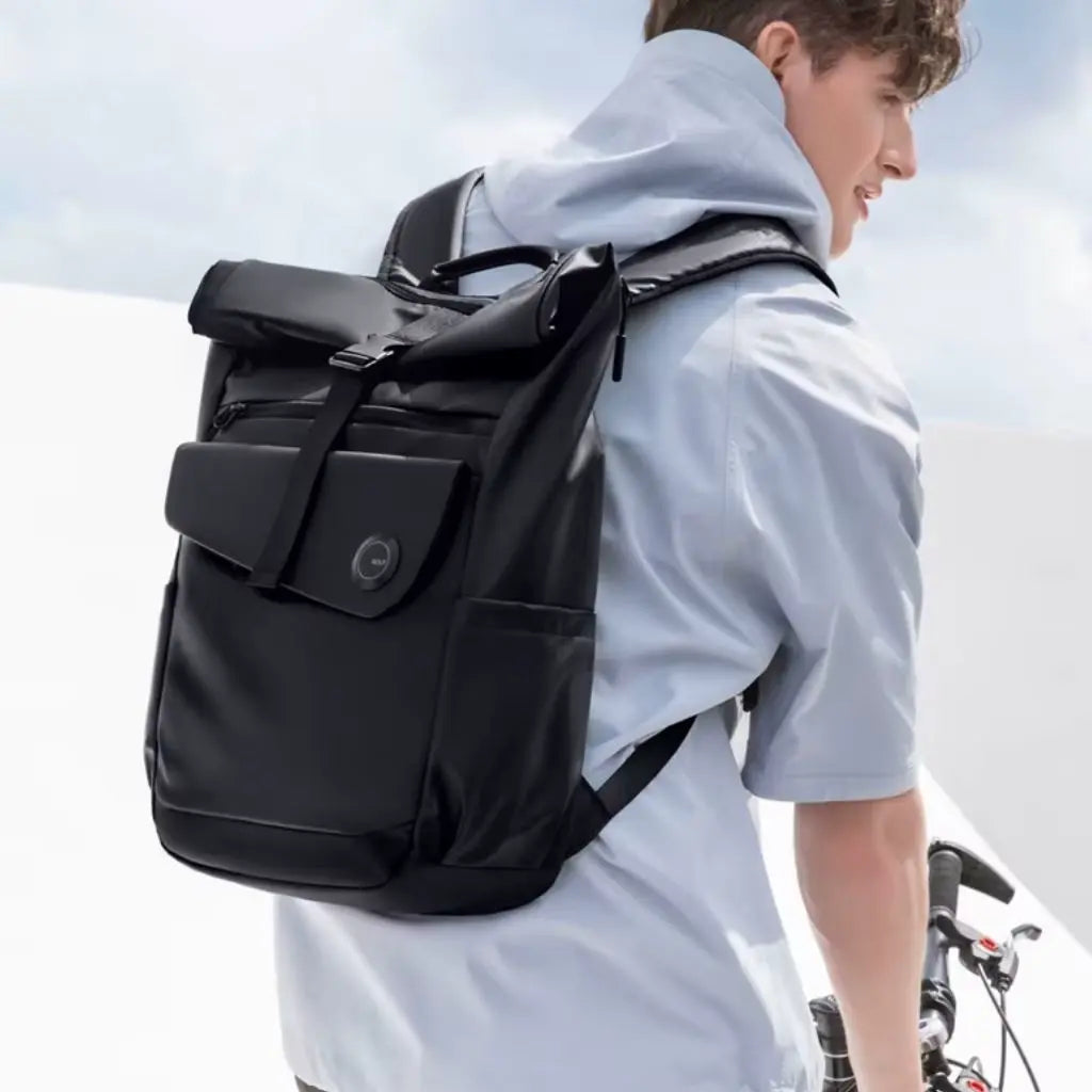 Man met laptop rugzak heren 16 inch fietst in een moderne omgeving, wat de veelzijdigheid en het comfort van de tas benadrukt.