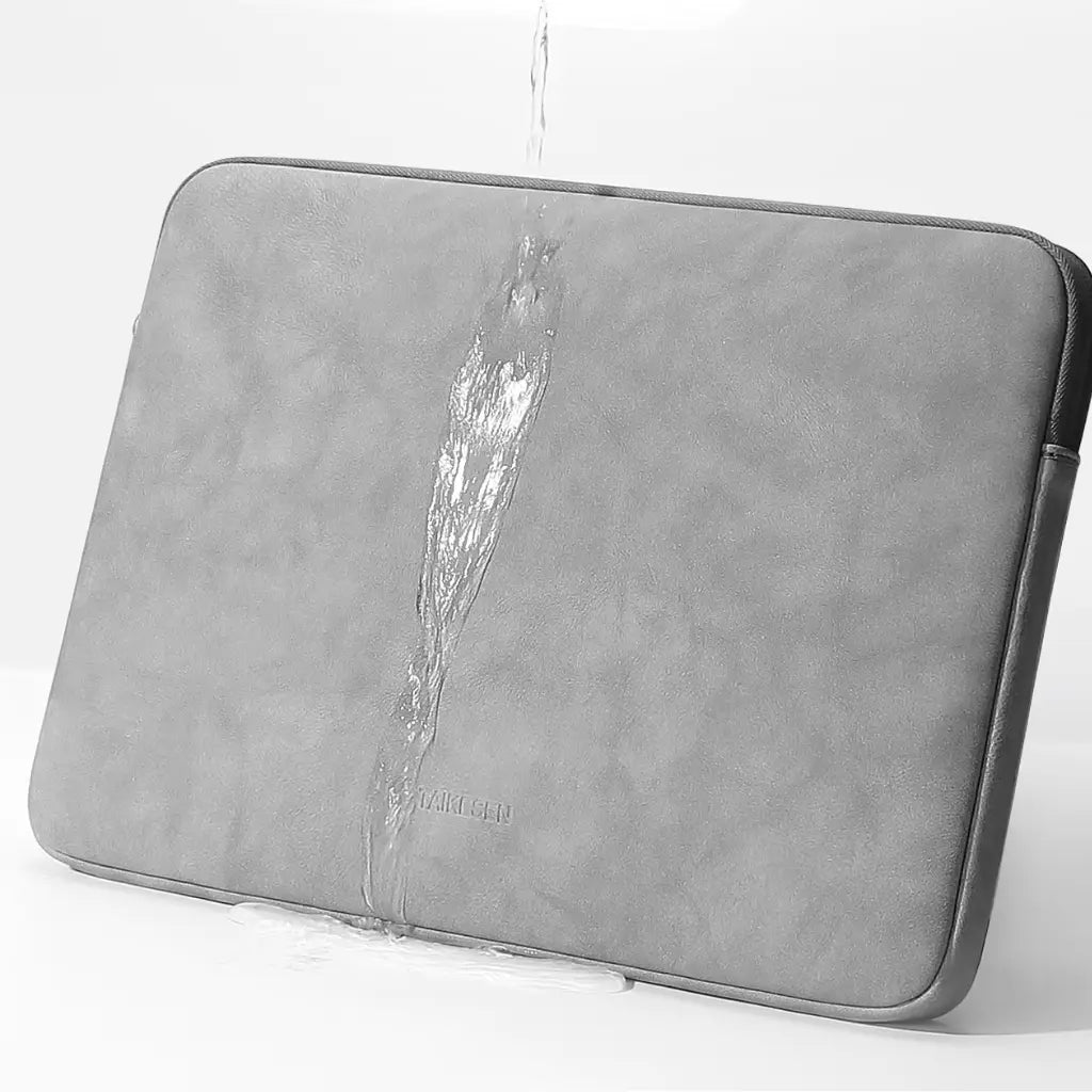 Waterdruppels op grijze laptop sleeve 14 inch demonstreren de waterafstotende eigenschappen
