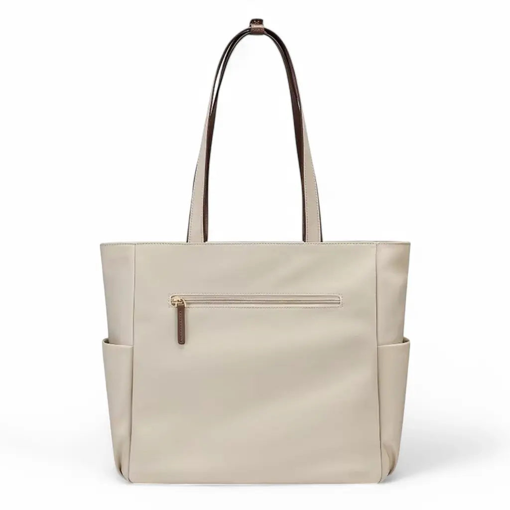 Achterzijde van een beige laptoptas dames 15.6 inch met horizontaal ritsvak en zijvakken voor extra opbergruimte. De laptoptas dames 15.6 inch beige toont de praktische indeling en hoogwaardige afwerking met bruine accenten en biedt een elegante uitstraling voor dagelijks gebruik.