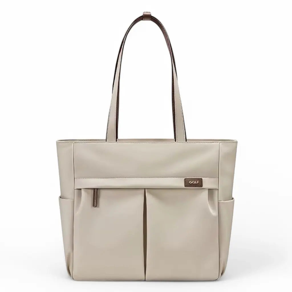 Een elegante beige laptoptas dames 15.6 inch met dubbele handgrepen in contrasterende bruine afwerking en twee voorvakken. De laptoptas dames 15.6 inch beige heeft een stijlvol GOLF merklogo, strak minimalistisch ontwerp en is vervaardigd uit hoogwaardig kunstleer, perfect voor professionele vrouwen.
