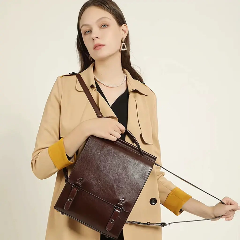 Vrouw met een beige jas draagt een leren laptop rugzak 13 inch, met verstelbare banden die zowel als rugzak als schoudertas kunnen worden gebruikt.