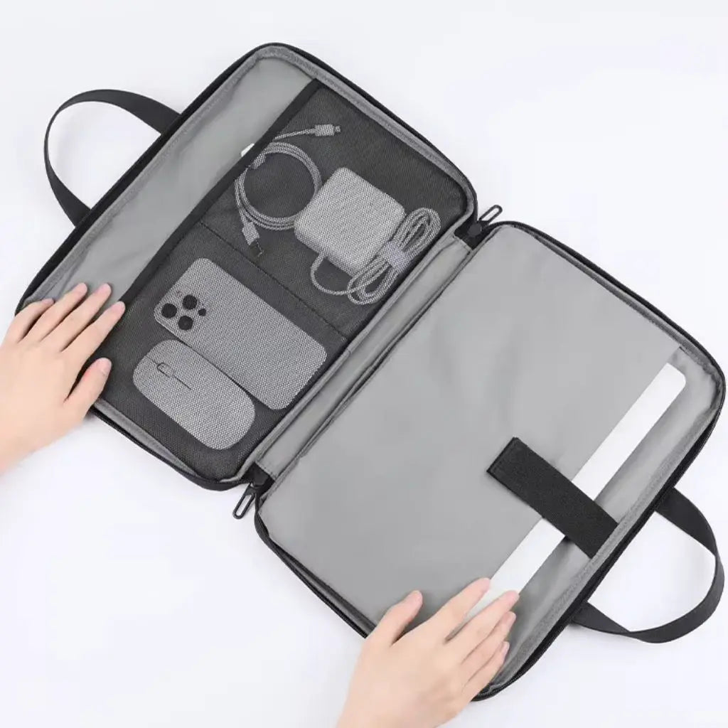 Overzicht van de binnenkant van een lichte laptoptas dames 17 inch grijs, met speciale vakken voor laptop, smartphone, kabels en accessoires, gedemonstreerd door twee handen die de tas openhouden.