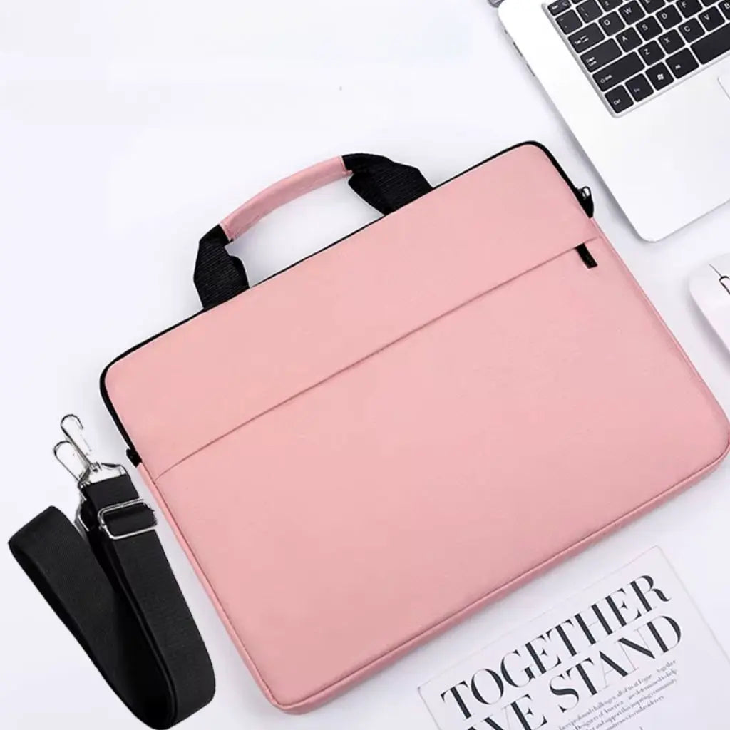 Bovenaanzicht van een laptoptas dames 17 inch roze naast een MacBook-laptop, met afneembare zwarte schouderband en een tijdschrift, ideaal voor dagelijks zakelijk gebruik.