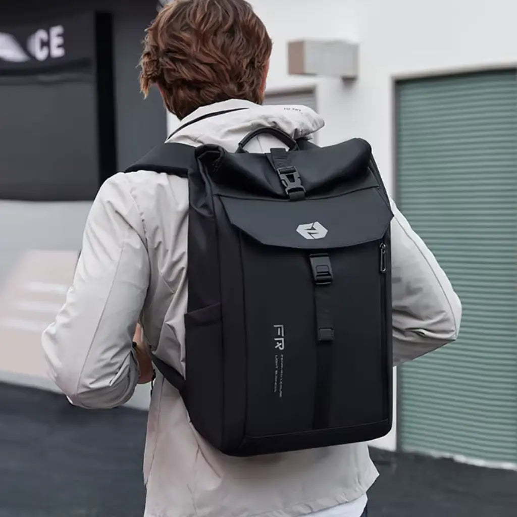 Achterkant van een man in lichte jas met zwarte Nomad laptop rugzak tijdens wandeling door de stad.