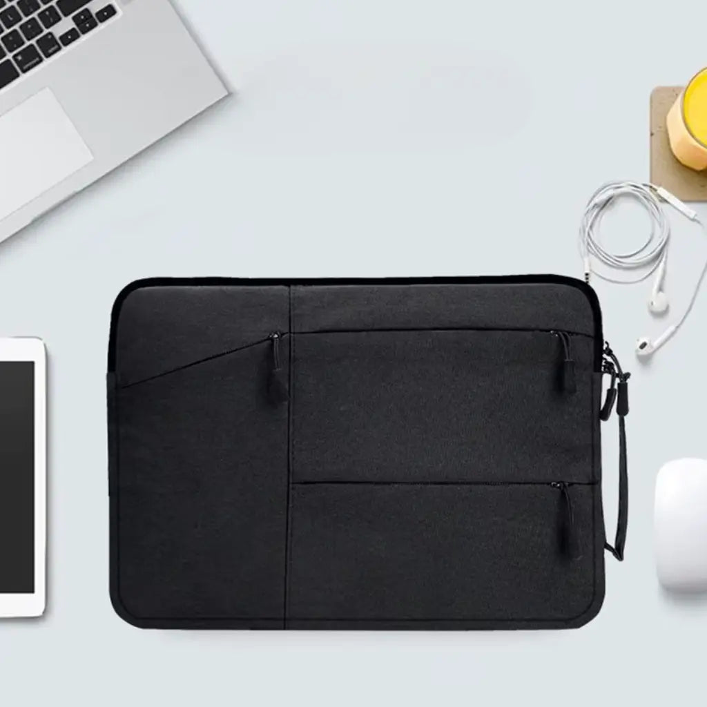 Laptop hoes zwart op een bureau met laptop, tablet en andere accessoires, perfecte oplossing voor werkplekorganisatie.