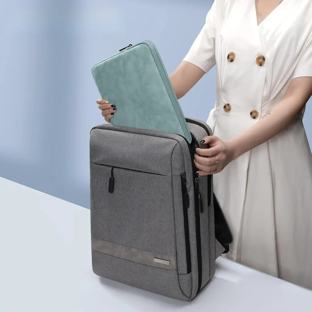 Vrouw plaatst mintgroene green laptop sleeve in een grijze laptoptas, ideale combinatie voor moderne professionals.