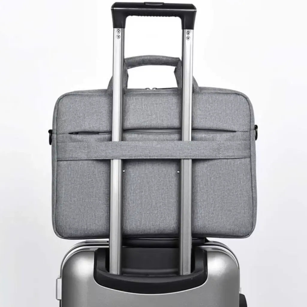 Laptoptas heren 13 inch grijs bevestigd aan een trolleykoffer dankzij de speciale band aan de achterzijde, ideaal voor zakenreizen en dagelijks woon-werkverkeer.