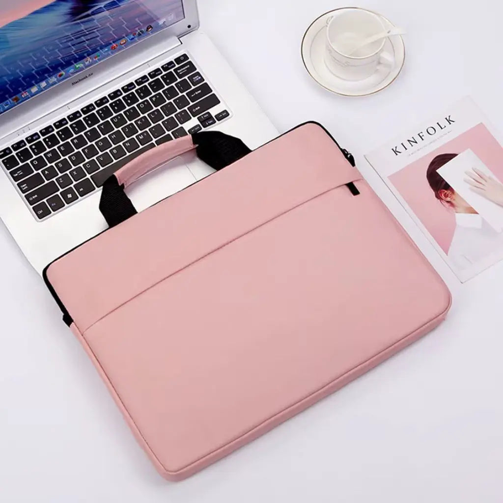 Laptoptas dames 17 inch roze op een witte werkplek naast een laptop, koffiekopje en KINFOLK magazine, een perfecte combinatie van functionaliteit en elegantie.