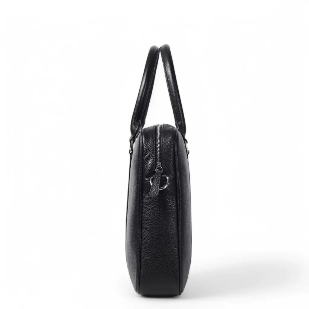 Zijaanzicht van een stoere laptoptas heren 14 inch in zwart leder. De slanke, compacte tas heeft een ritssluiting aan de bovenkant en is gemaakt van hoogwaardig getextureerd leer met een subtiele korrelstructuur, perfect voor dagelijks professioneel gebruik.