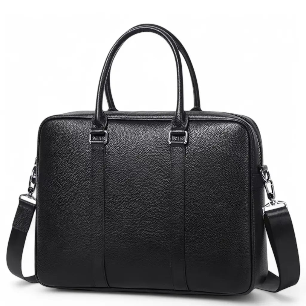 Stoere laptoptas heren 14 inch in zwart leer met een strakke, minimalistische uitstraling. De tas heeft ergonomische handgrepen, verticale verstevigingsstrips en wordt geleverd met een afneembare, verstelbare schouderriem voor extra draagcomfort tijdens het woon-werkverkeer.