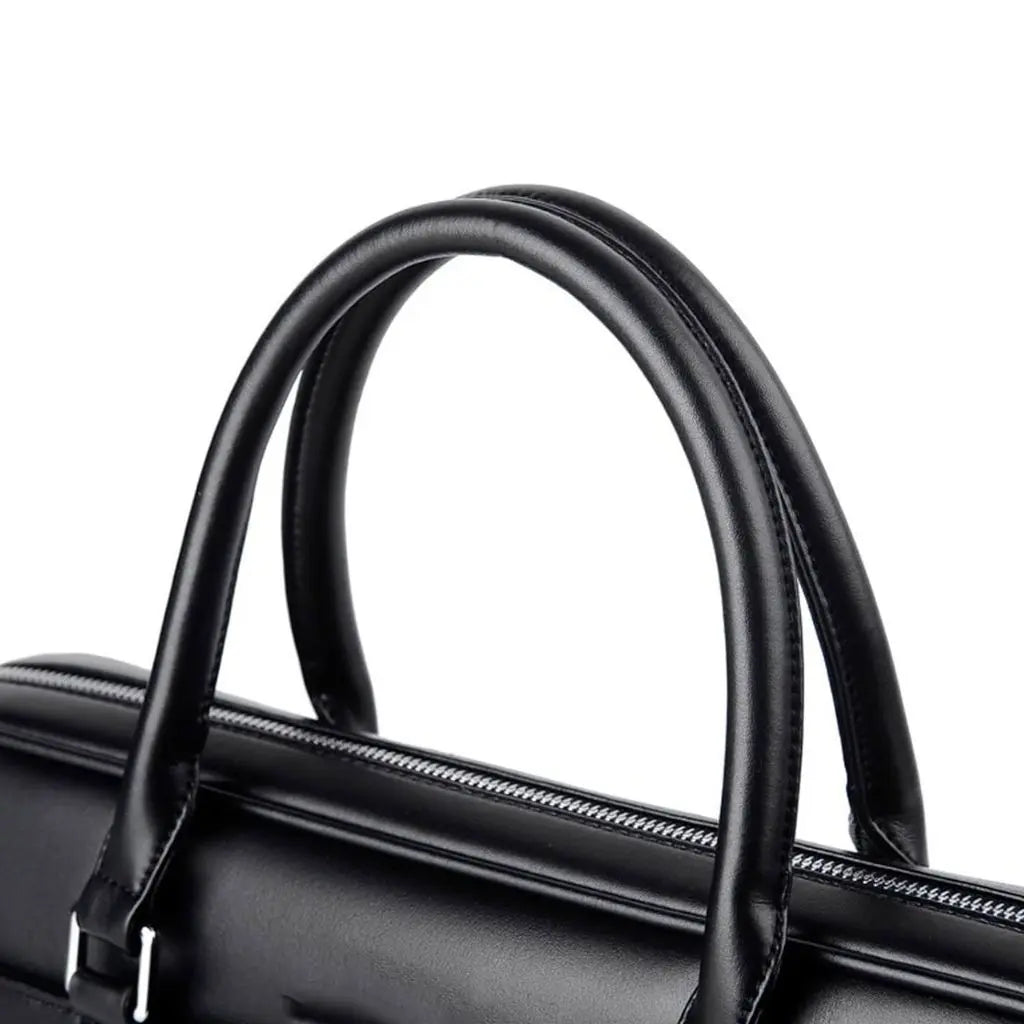 Close-up van het handvat van de stoere leren laptoptas 13 inch. De ergonomisch gevormde, dikke leren handgrepen zijn stevig bevestigd met metalen accessoires, wat zorgt voor comfort en duurzaamheid bij het dragen van deze elegante zwarte laptoptas.