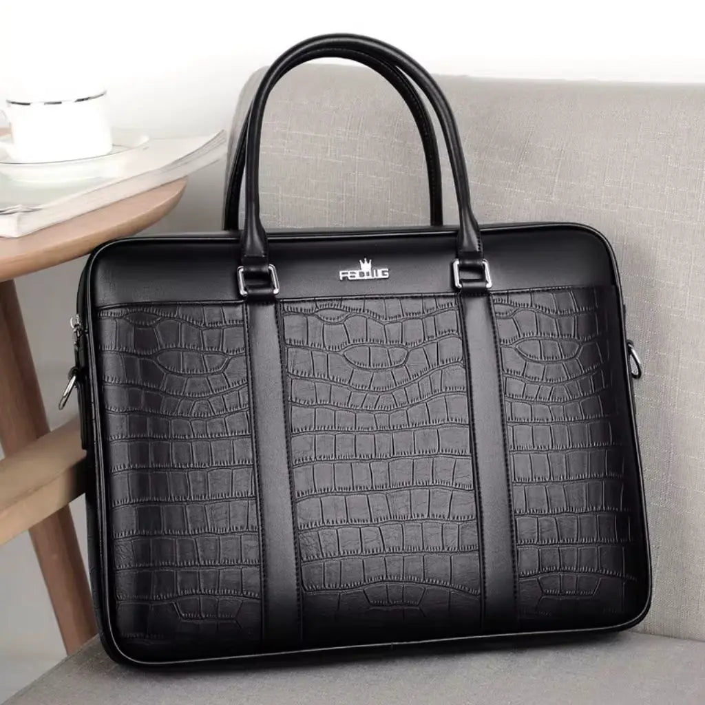Stoere leren laptoptas 13 inch rustend op een lichtgrijze bank. De zwarte laptoptas met krokodillenprint en het FEIDKAS-logo is voorzien van stevige handvaten en zijritssluitingen, ideaal voor dagelijks professioneel gebruik.