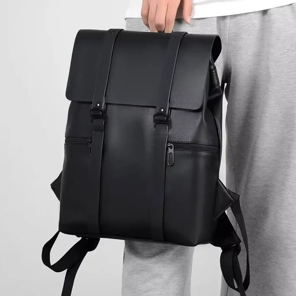 Zijkant van een waterdichte laptop rugzak 14 inch zwart wordt vastgehouden door iemand in vrijetijdskleding, wat de slanke vormgeving en praktische draagbaarheid van deze veelzijdige rugzak demonstreert.