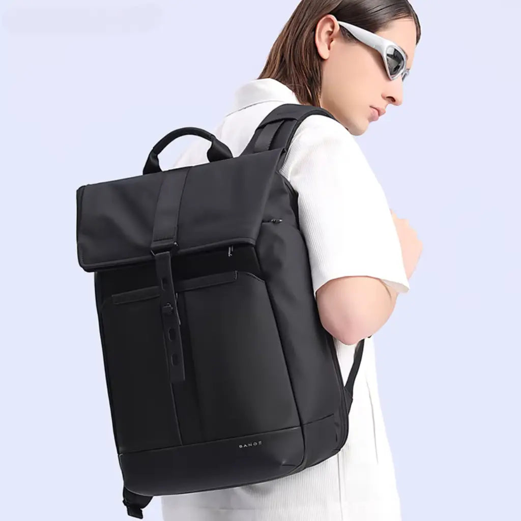 Vrouw met zonnebril draagt de zwarte waterdichte laptop rugzak 15 inch in combinatie met een witte outfit.