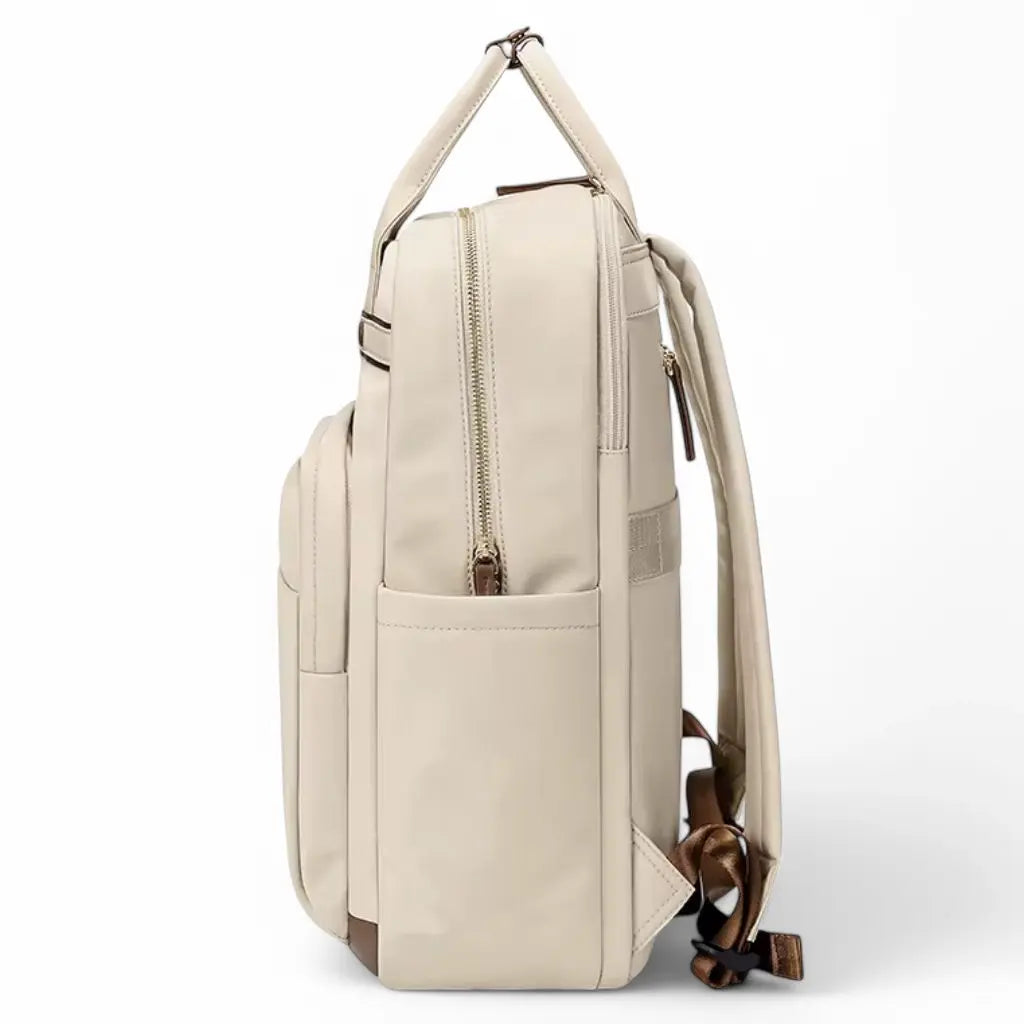 Een waterdichte laptop rugzak 15.6 inch beige gefotografeerd vanaf de zijkant. Deze opname toont de slank profiel van de rugzak met stevige handgreep aan de bovenkant, verstevigde rugbanden en zijvakken. Het hoogwaardige materiaal en de bruine details geven de rugzak een luxe uitstraling.